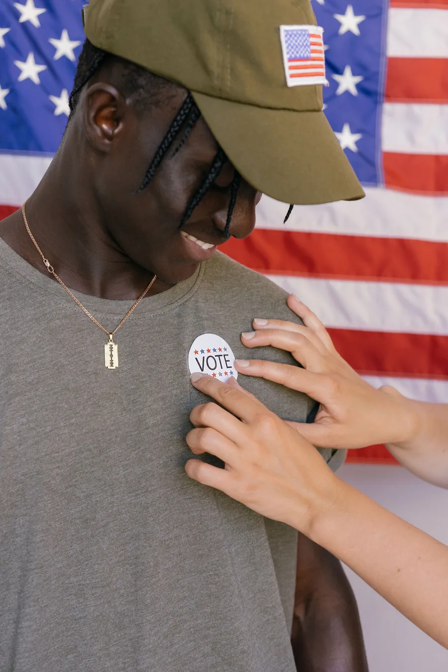 A voter getting a VOTE sticker in front of an American flag